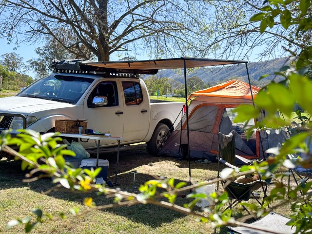 Roll-out side awning extended from a 4WD at camp